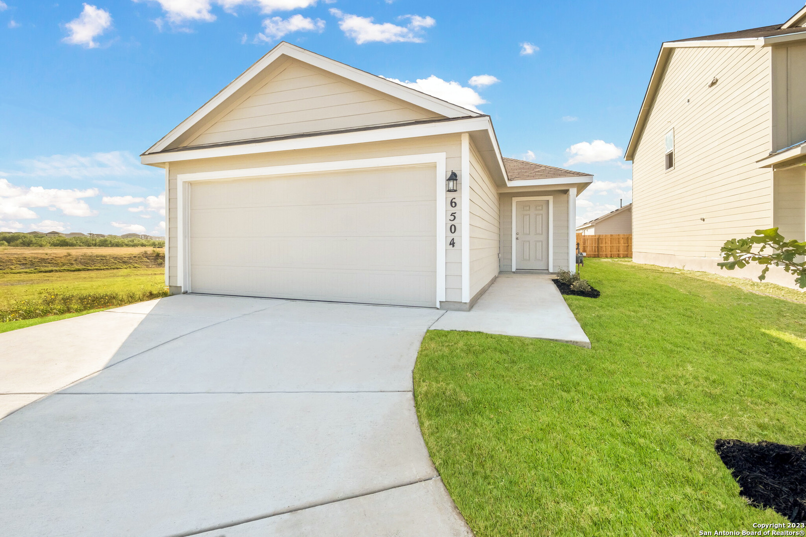6950 Biotite Ridge Elmendorf, TX 78112 - Photo 1 of 1 a view of a big house with wooden fence