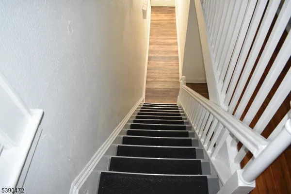 a view of staircase with wooden floor and white walls