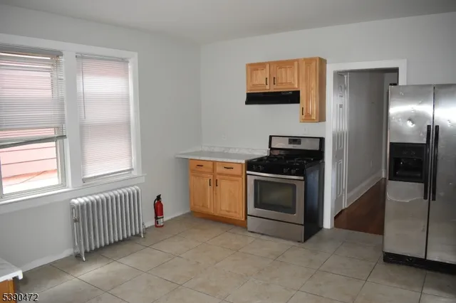 a kitchen with a refrigerator and a stove top oven