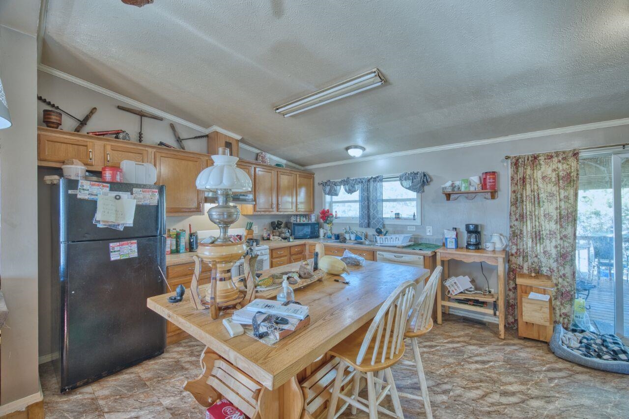3932 Hwy 100 Aurora Mn 55705 Aurora, MN 55705 - Photo 12 of 44 Kitchen featuring freestanding refrigerator, crown molding, vaulted ceiling, a textured ceiling, and stove
