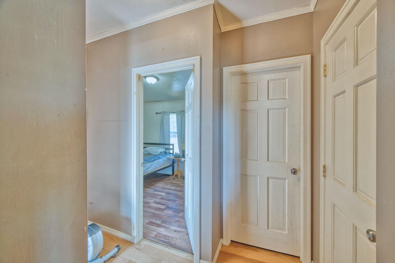 3932 Hwy 100 Aurora Mn 55705 Aurora, MN 55705 - Photo 14 of 44 Corridor with light wood-style flooring and ornamental molding