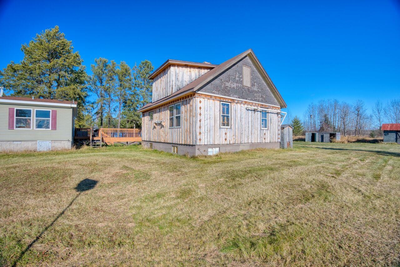 3932 Hwy 100 Aurora Mn 55705 Aurora, MN 55705 - Photo 25 of 44 View of side of home featuring a lawn, a wooden deck, crawl space, and an outdoor structure