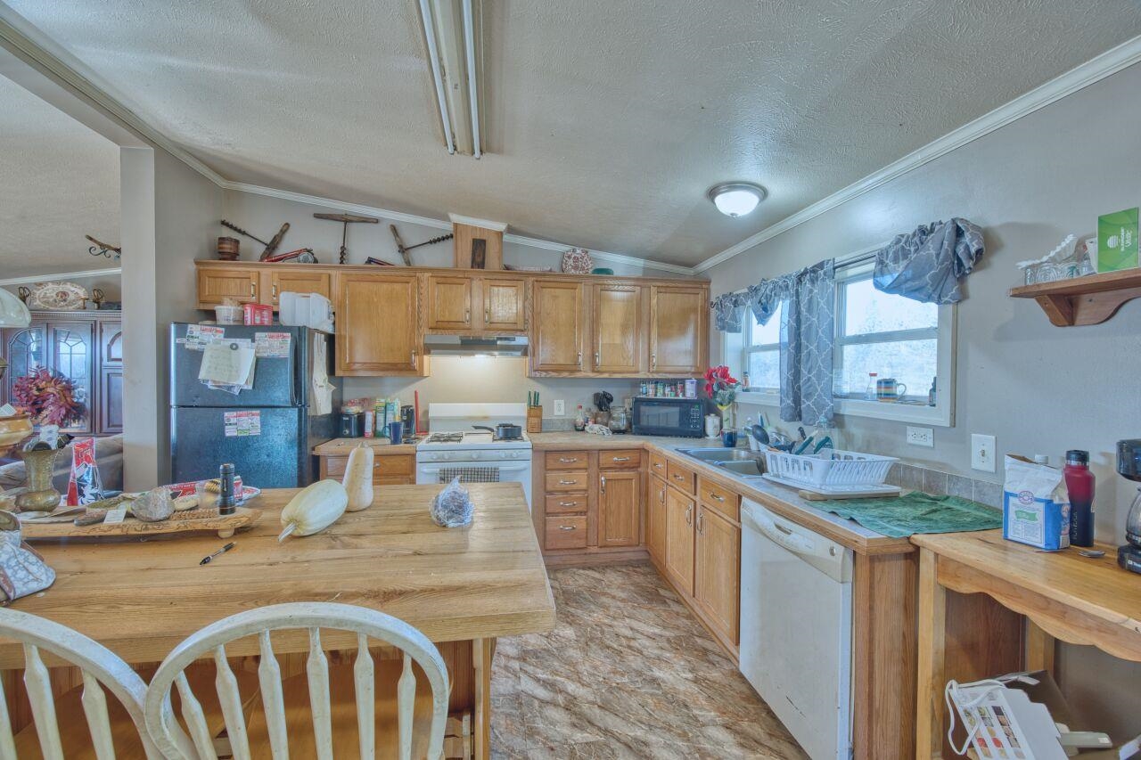 3932 Hwy 100 Aurora Mn 55705 Aurora, MN 55705 - Photo 6 of 44 Kitchen featuring ornamental molding, a textured ceiling, black appliances, light countertops, and vaulted ceiling