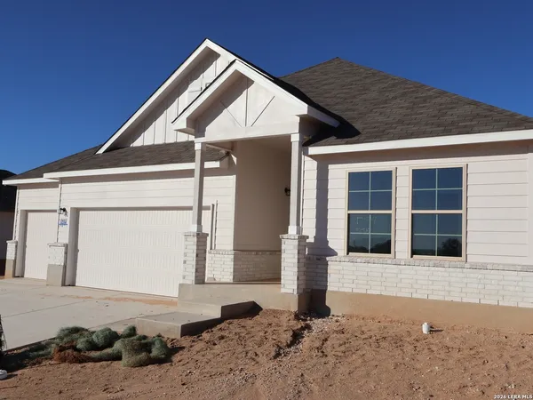 a large white kitchen with granite countertop a stove a sink a refrigerator with white cabinets and wooden floor