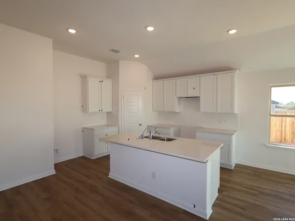 a kitchen with a sink cabinets and wooden floor
