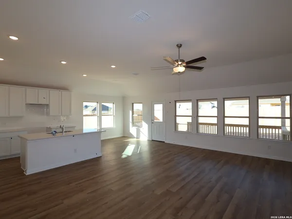 a view of an empty room with window and wooden floor