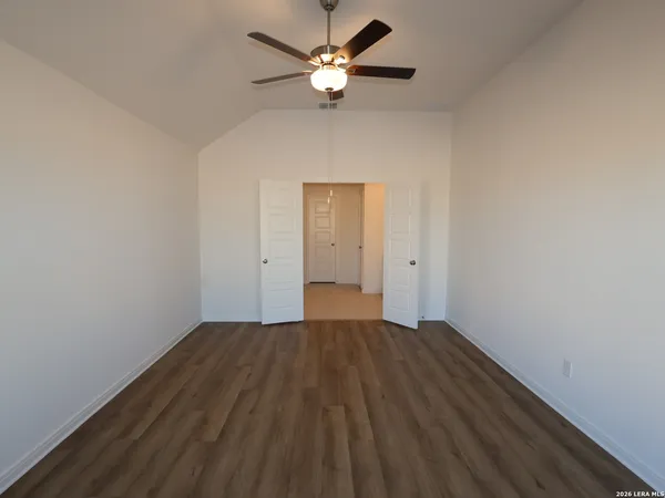 an empty room with a window and a fan