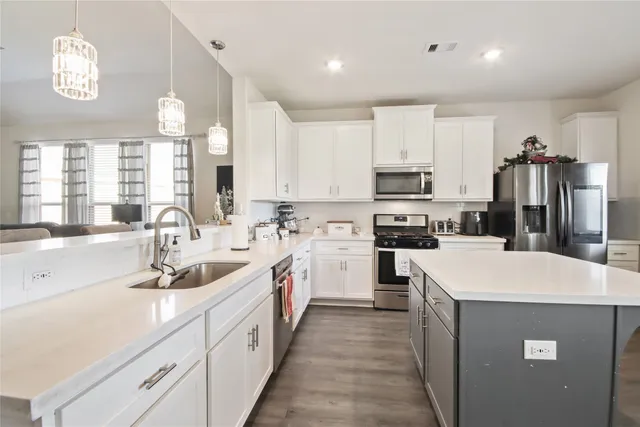 a kitchen that has a lot of cabinets a sink and a stove