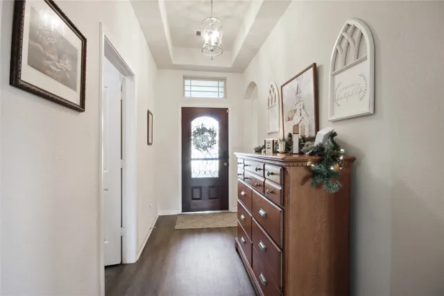 a view of a hallway with wooden floor and windows