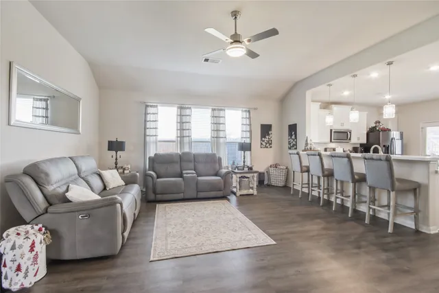 a living room with furniture wooden floor and windows