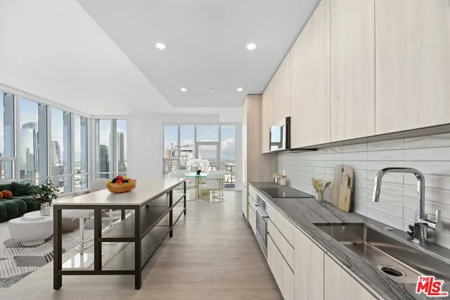 a kitchen with stainless steel appliances granite countertop a sink and a refrigerator