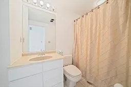 a bathroom with a sink a toilet and shower curtain