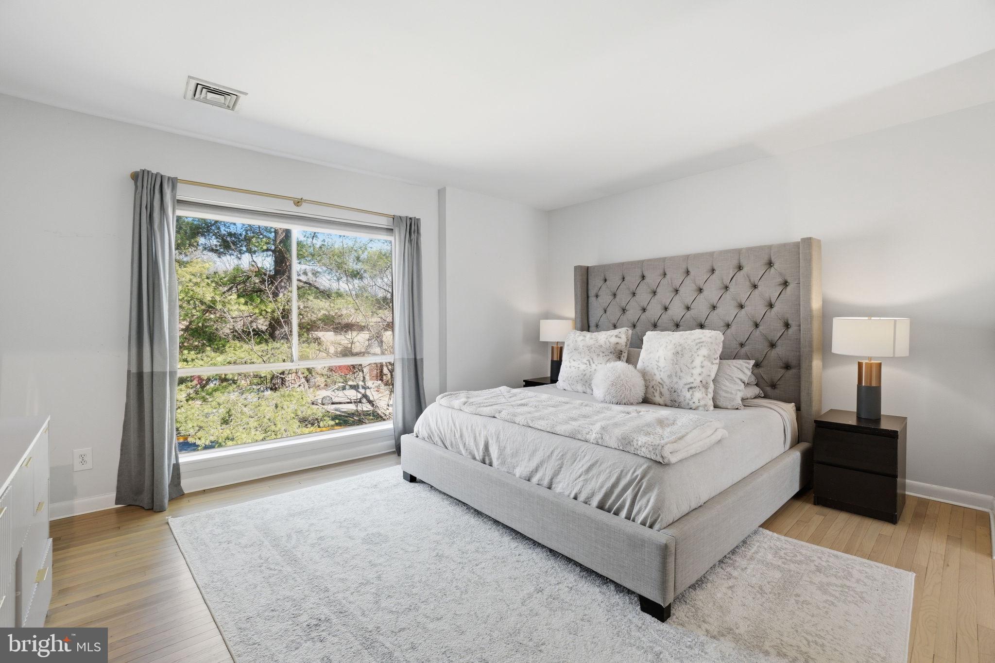 11025 Saffold Way Reston, VA 20190 - Photo 12 of 50 a bedroom with a large bed and wooden floor