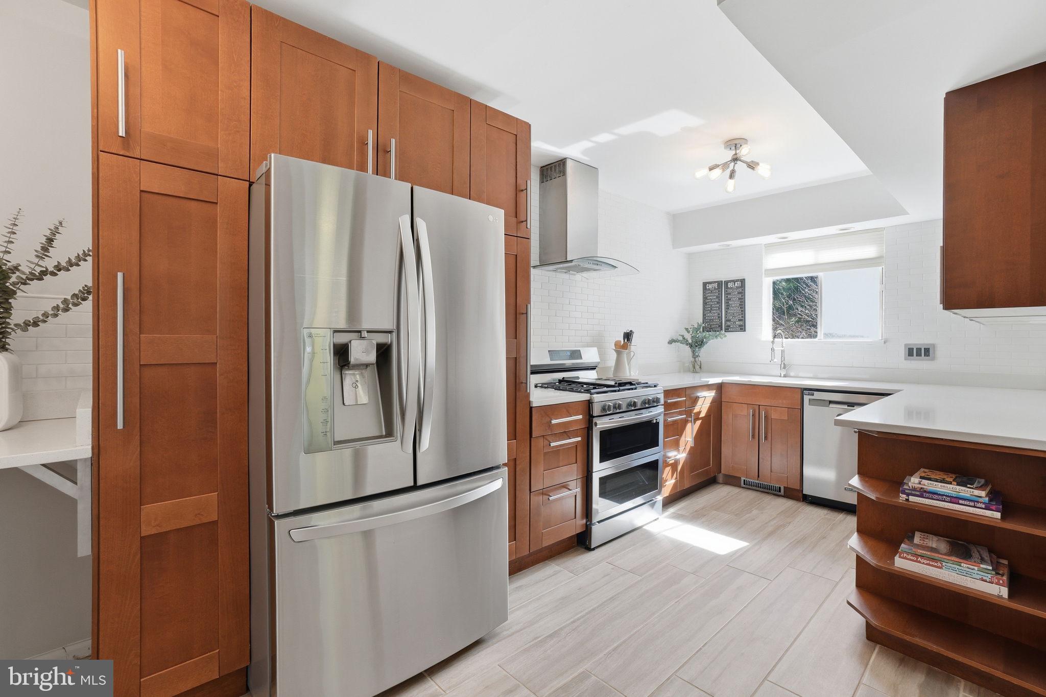 11025 Saffold Way Reston, VA 20190 - Photo 8 of 50 a kitchen with stainless steel appliances a refrigerator a stove a sink cabinets and a refrigerator