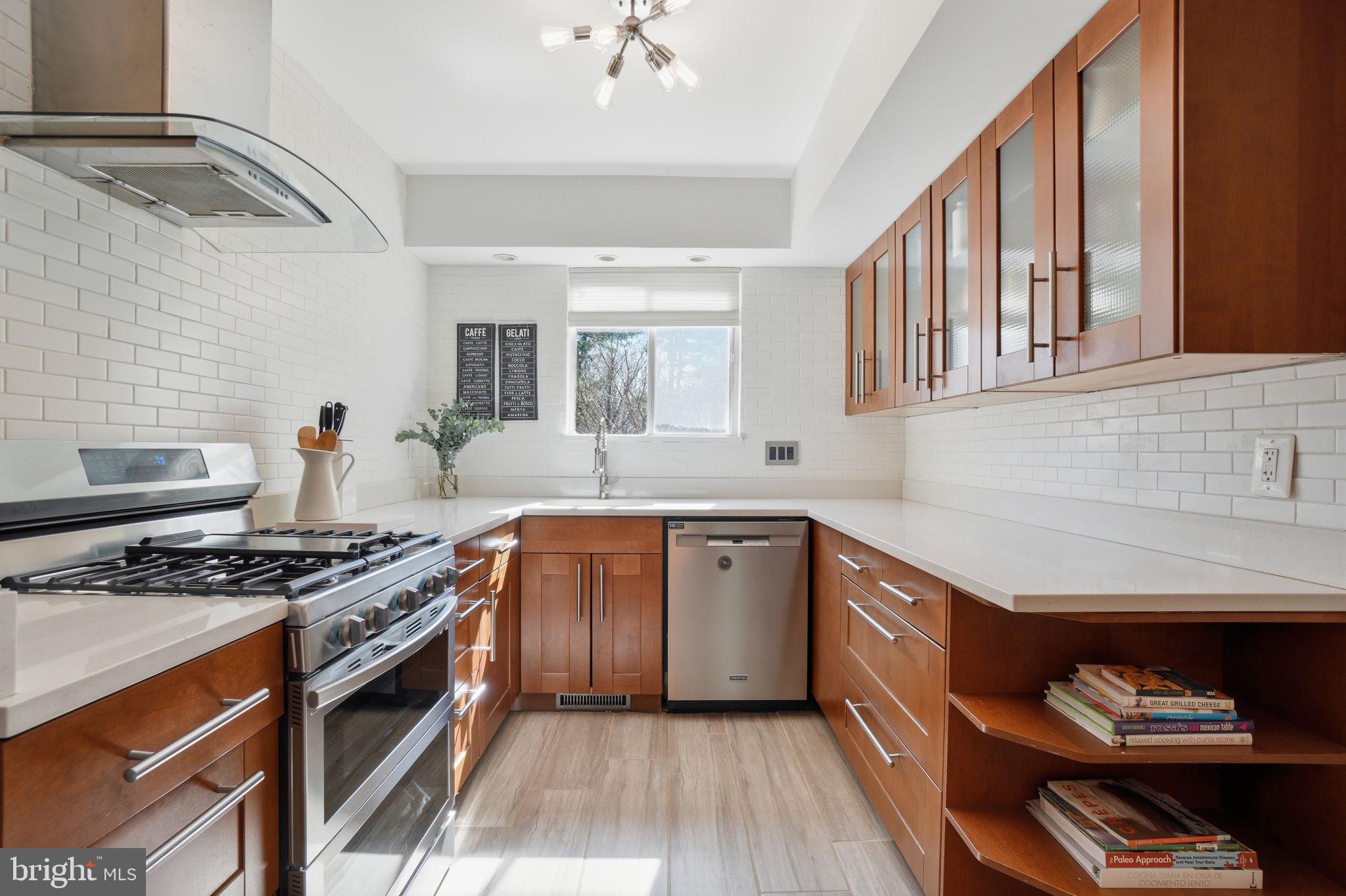 11025 Saffold Way Reston, VA 20190 - Photo 9 of 50 a kitchen with stainless steel appliances granite countertop a stove and a sink