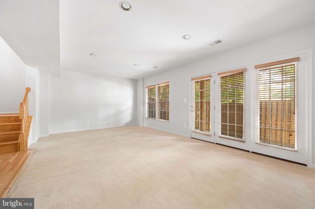 a view of a backyard with wooden fence and a large tree