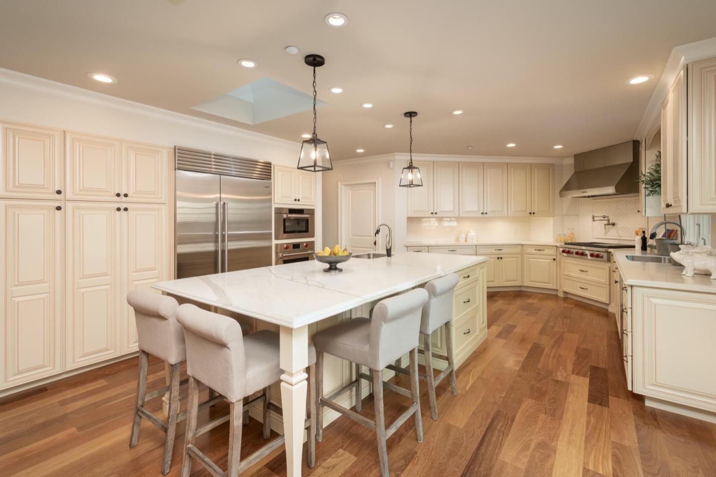 521 Roehampton Road Hillsborough, CA 94010 - Photo 18 of 51 a kitchen with stainless steel appliances kitchen island granite countertop a table chairs sink and cabinets