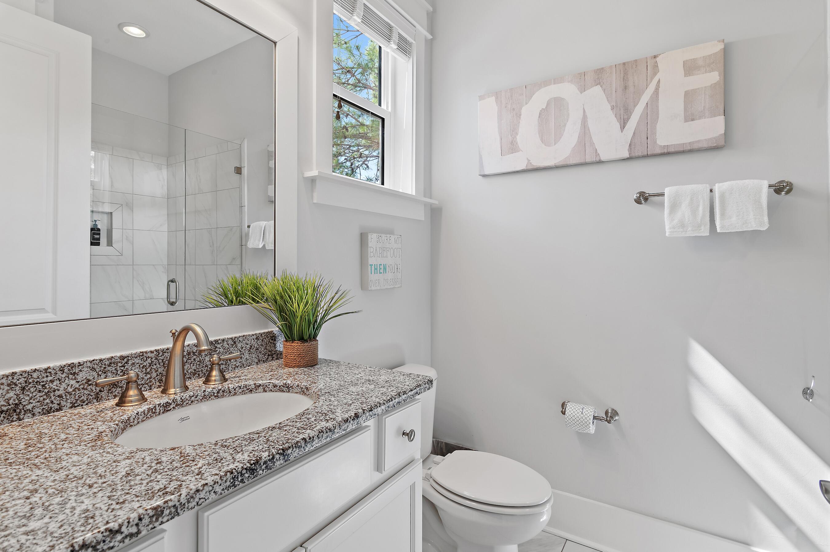 260 Flatwoods Forest Loop Santa Rosa Beach, FL 32459 - Photo 16 of 32 a bathroom with a granite countertop sink a toilet and a mirror