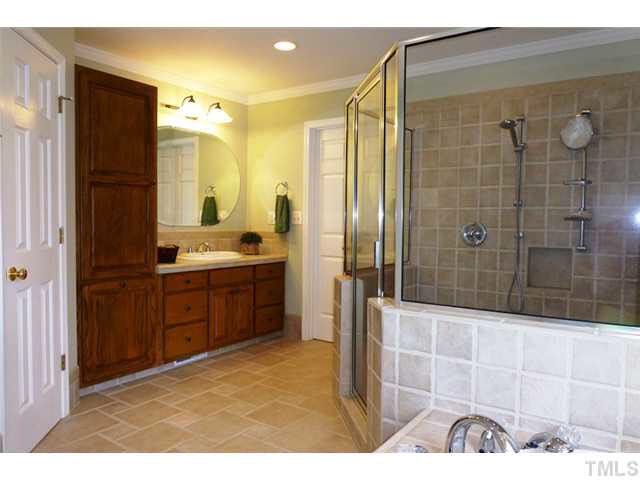 1555 Hanford Road Graham, NC 27253 - Photo 13 of 25 a bathroom with a double vanity sink a large mirror and shower