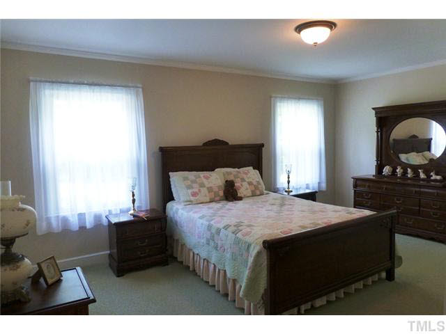 1555 Hanford Road Graham, NC 27253 - Photo 14 of 25 a bedroom with a bed a dresser next to a window