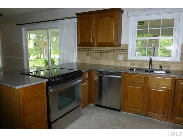 1555 Hanford Road Graham, NC 27253 - Photo 9 of 25 a kitchen with granite countertop a sink stainless steel appliances and cabinets