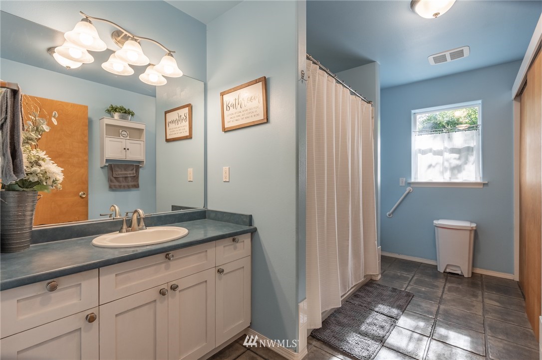 9579 Delta Line Road Blaine, WA 98230 - Photo 22 of 40 a bathroom with a granite countertop sink a toilet and a mirror
