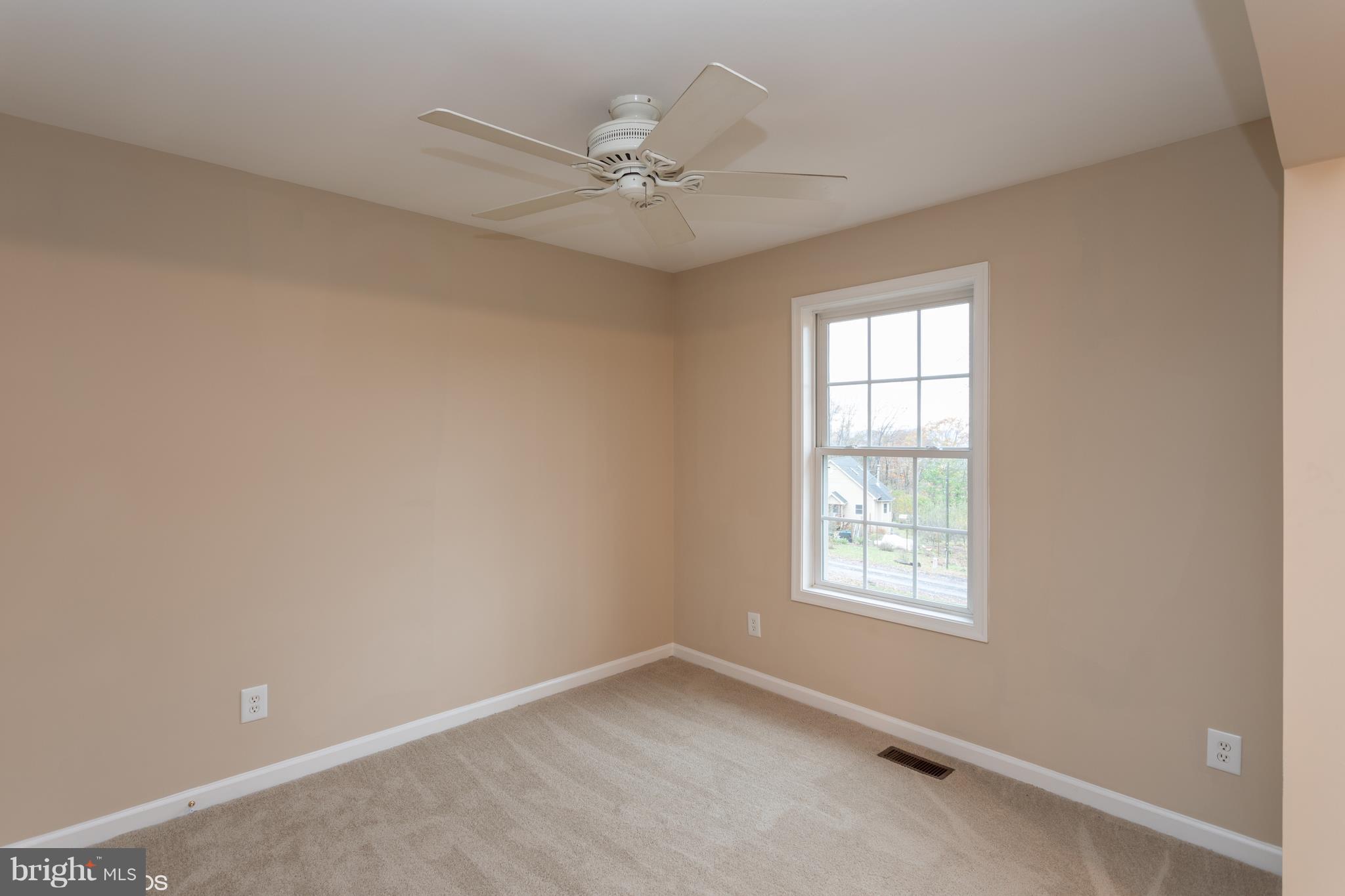 322 Freeze Road Linden, VA 22642 - Photo 4 of 26 an empty room with a window and a fan