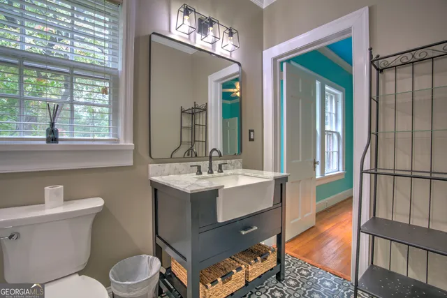 a bathroom with a sink a toilet a mirror and window