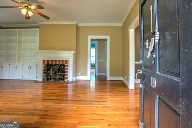 a view of a livingroom with a fireplace wooden floor and staircase