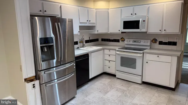 a kitchen with stainless steel appliances granite countertop a refrigerator stove a sink and a microwave