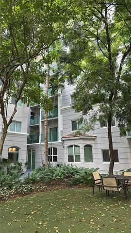 a white house that has a tree in front of it