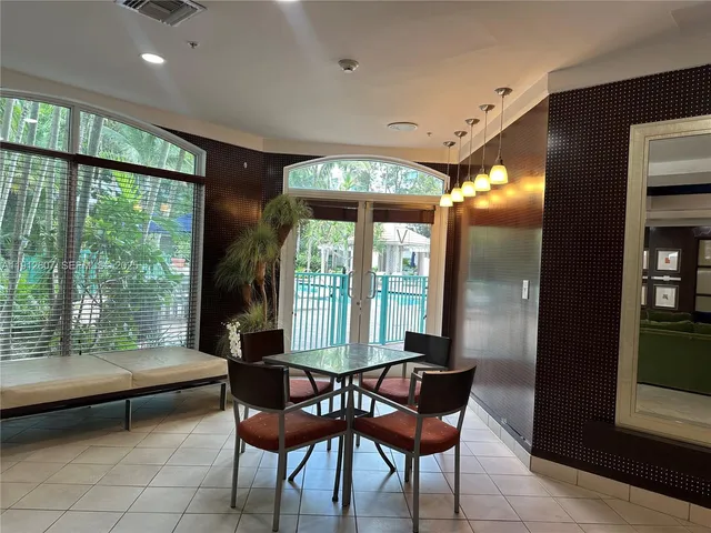 a dining room with furniture and a floor to ceiling window
