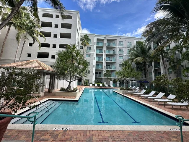 a view of a swimming pool with chairs and plants