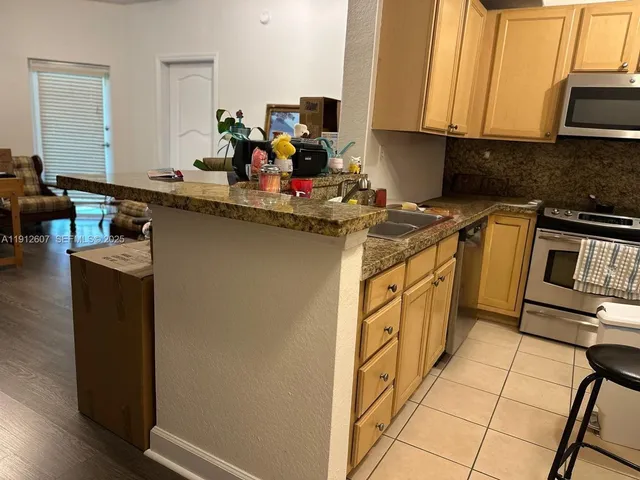 a kitchen with stainless steel appliances a sink stove and cabinets