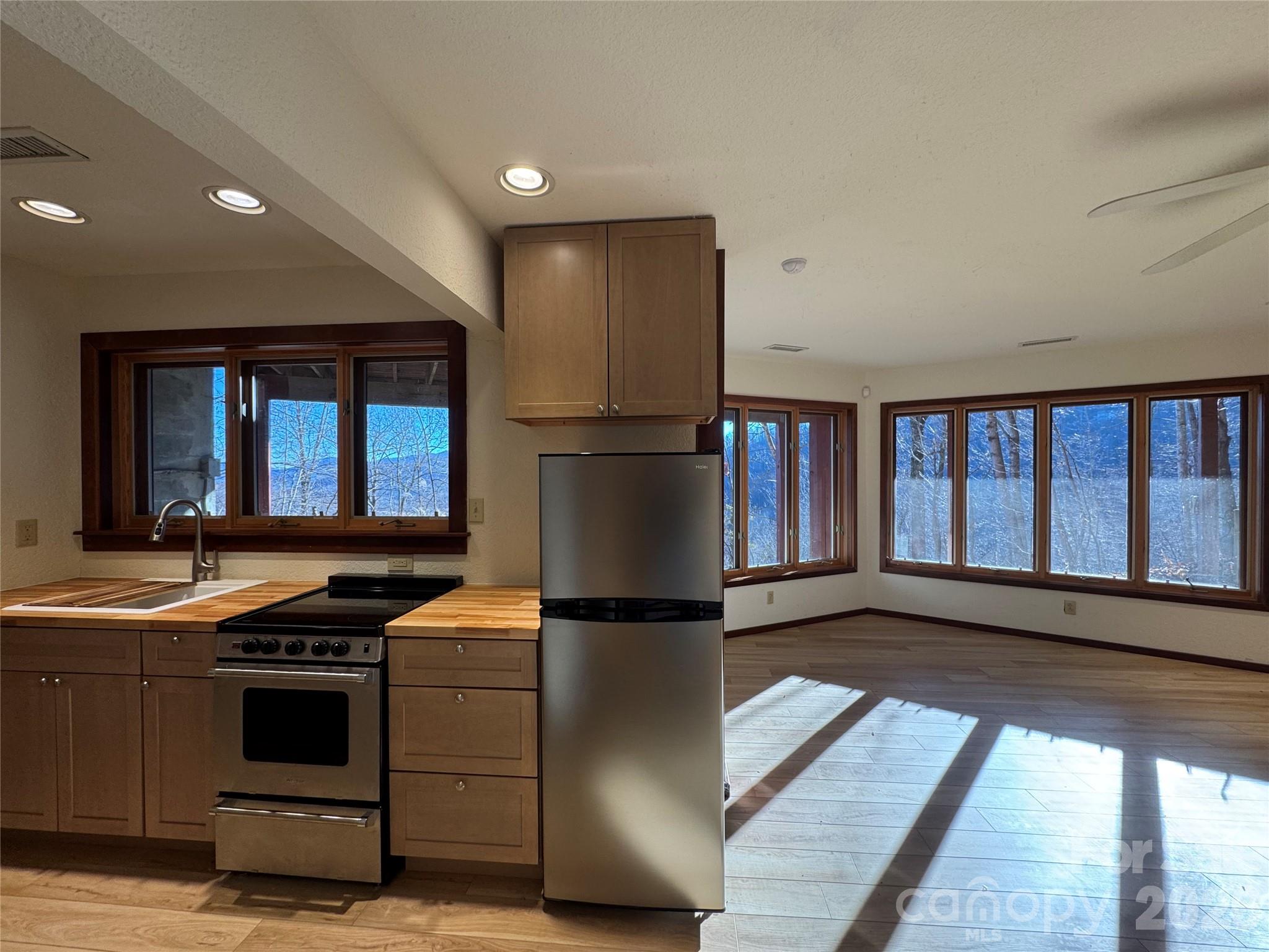 7 Winding Poplar Road Black Mountain, NC 28711 - Photo 35 of 48 a kitchen with stainless steel appliances granite countertop a refrigerator a stove and a sink with wooden floor