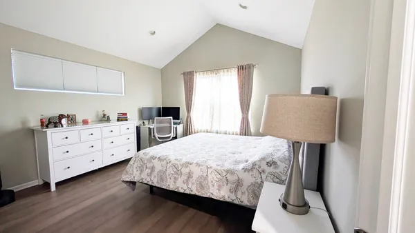 a bedroom with a bed and wooden floor