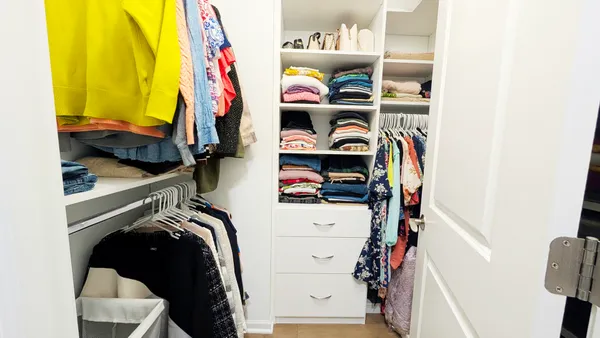 a view of walk in closet with clothes and shoes