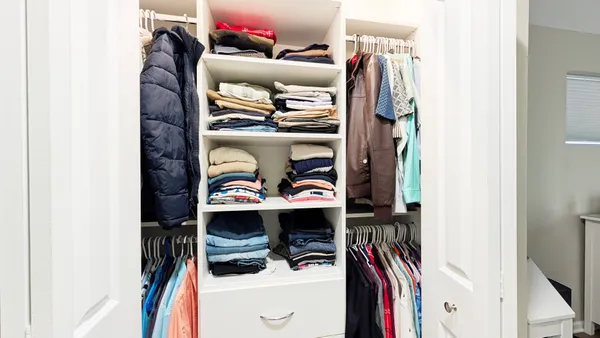 a view of walk in closet with clothes and shoes