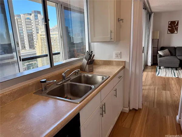 a kitchen with a sink and wooden floor