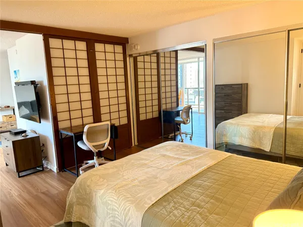 a bedroom with a bed chair and a large window