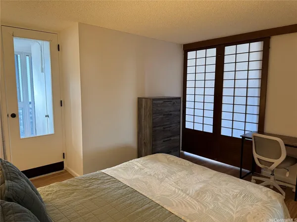a bedroom with a bed and wooden floor