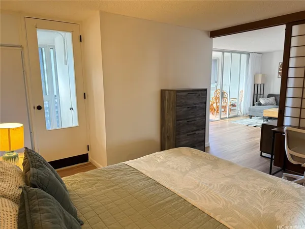 a bedroom with a bed and wooden floor