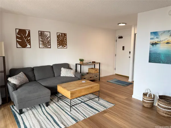 a living room with furniture and a wooden floor