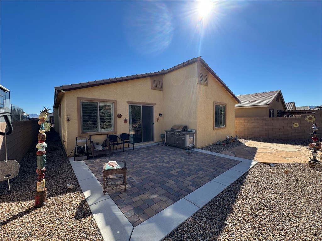 2128 Delmar Farms Court Laughlin, NV 89029 - Photo 34 of 36 Rear view of property featuring a fenced backyard, a patio area, stucco siding, and a tiled roof