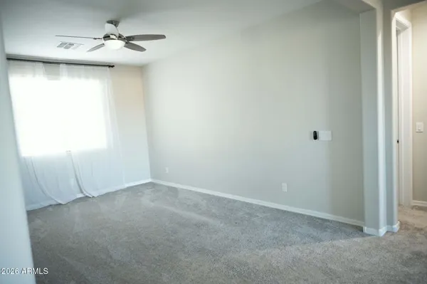an empty room with windows and fan