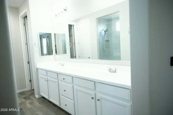 a bathroom with double vanity sink and a mirror