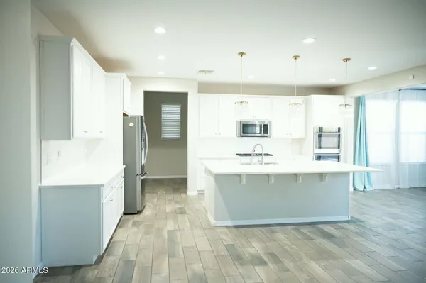 a view of kitchen with stainless steel appliances cabinets and wooden floor