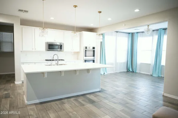a view of kitchen with stainless steel appliances kitchen island sink and refrigerator