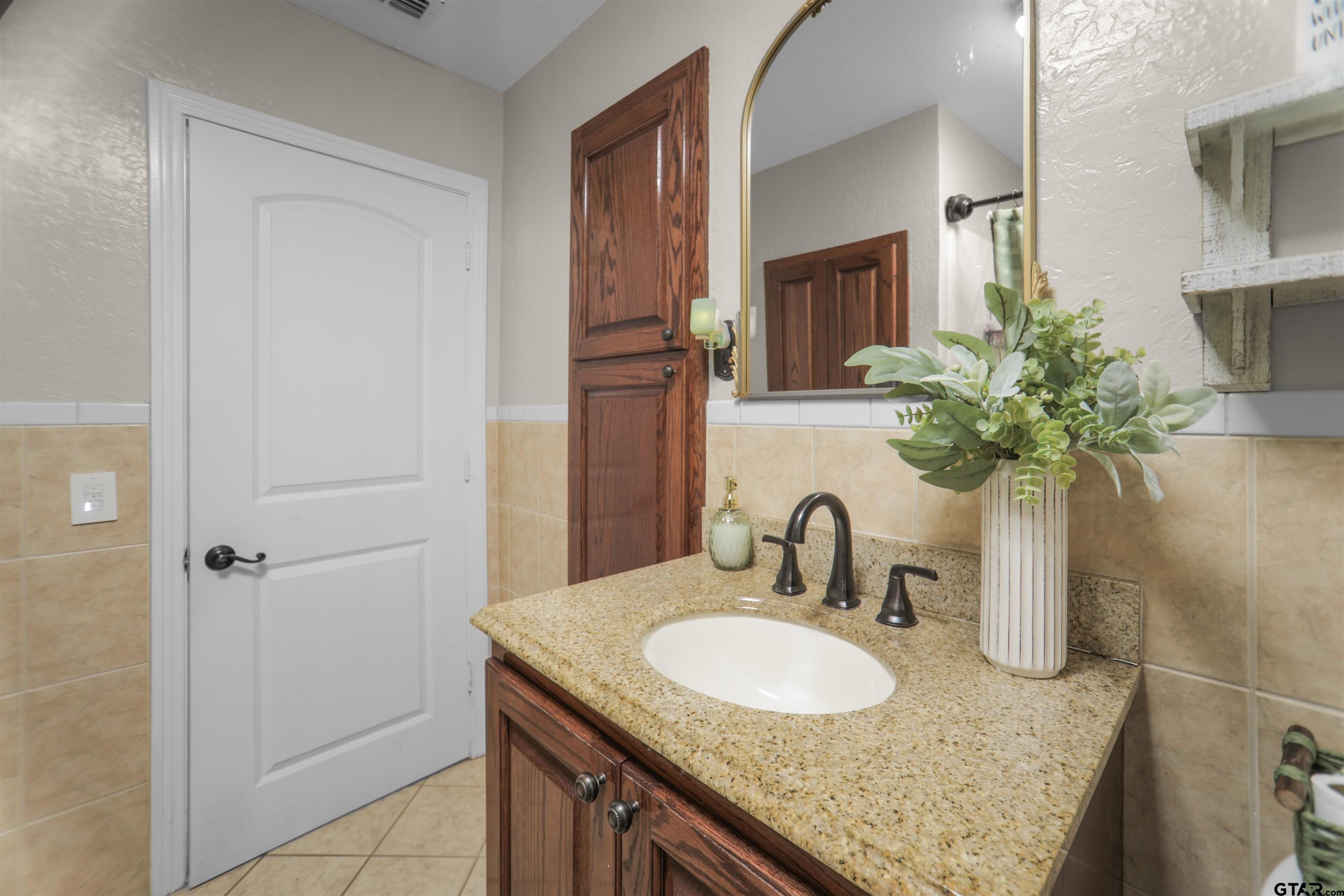 11931 State Highway 64 Tyler, TX 75704 - Photo 20 of 44 a bathroom with a granite countertop sink and a mirror
