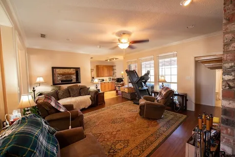 a living room with furniture kitchen view and a wooden floor